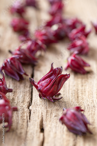 Roselle Hibiscus sabdariffa red fruit flower on wooden background. used for making tea or syrup. selective focus.