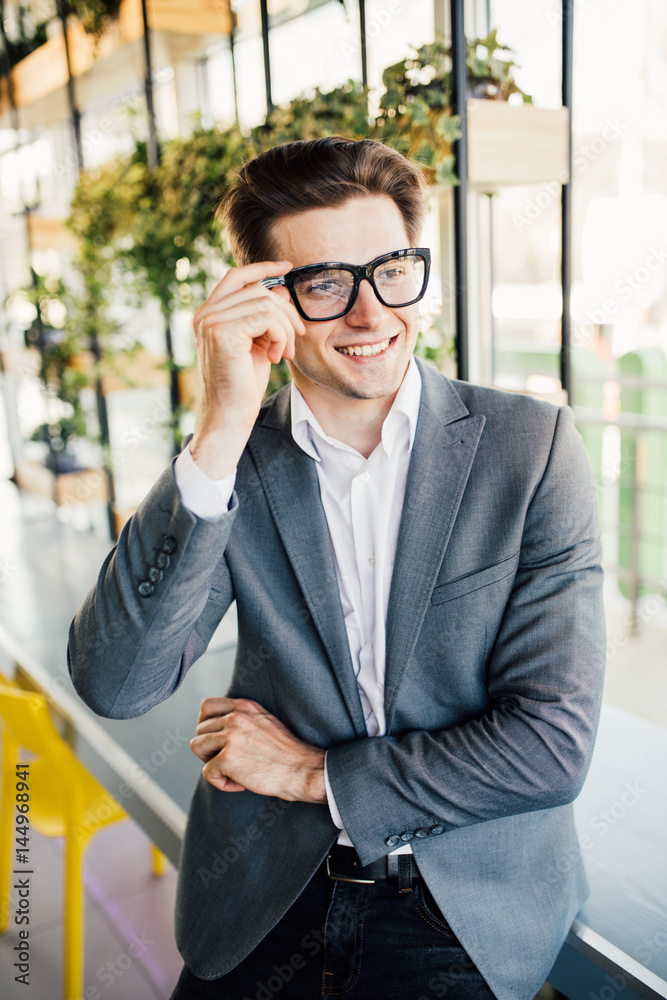 Handsome smiling confident businessman portrait in office Handsome smiling confident businessman portrait in office