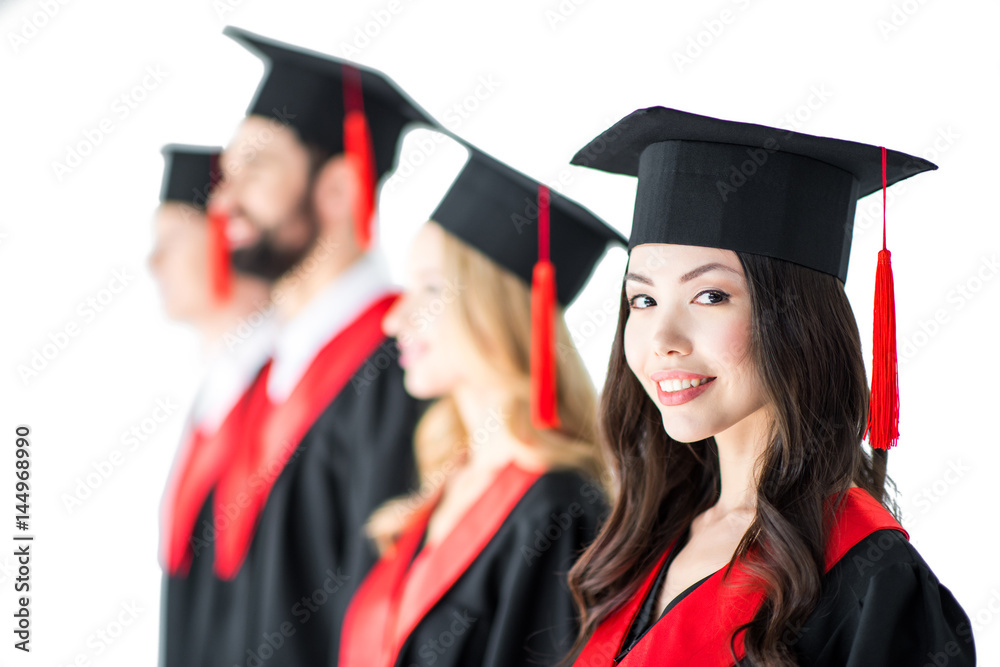attractive student in graduation cap with diploma, with friends behind isolated on white attractive student in graduation cap with diploma, with friends behind isolated on white