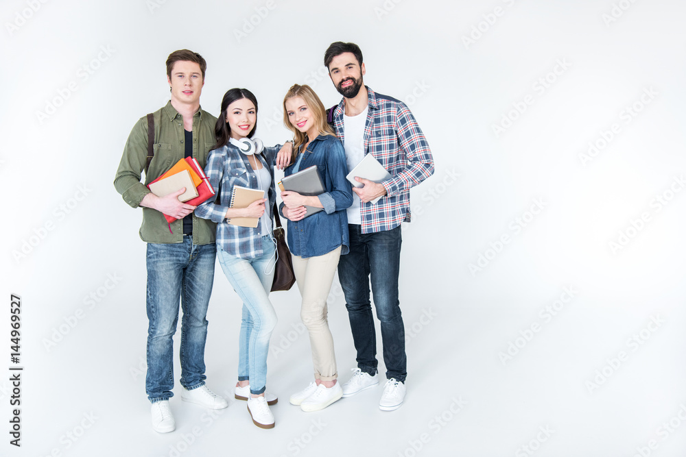 four young students in casual clothes holding books on white four young students in casual clothes holding books on white