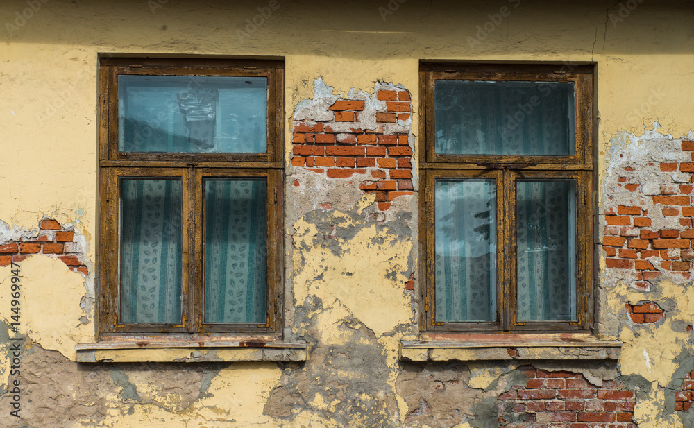 Fragment of yellow vintage old brick wall with windows. Textural background. Daugavpils, Latvia.