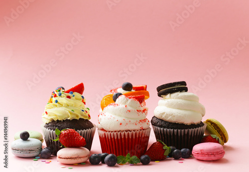 Платно festive cupcakes with berries and macaroons