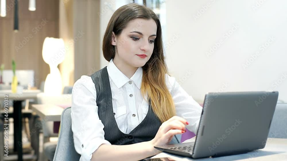 Businesswoman answers cellphone while working on laptop in the cafe
Businesswoman answers cellphone while working on laptop in the cafe
