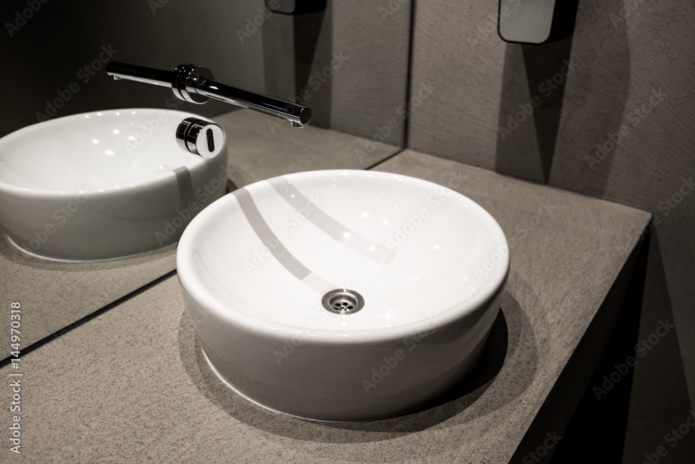 Fototapeta premium Modern european ceramic sink, Washstands with photocells, Public toilet with wash basins detail, Contemporary European white sink, Ceramic sink with contactless sensor, Symbol of modern cleansing