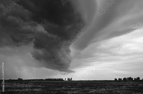 Thunderstorm over the field. Black and white