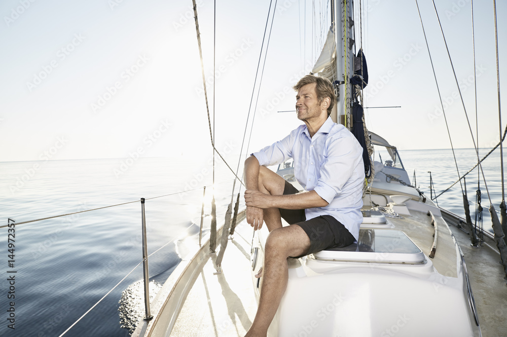 Smiling mature man relaxing on his sailing boat Smiling mature man relaxing on his sailing boat