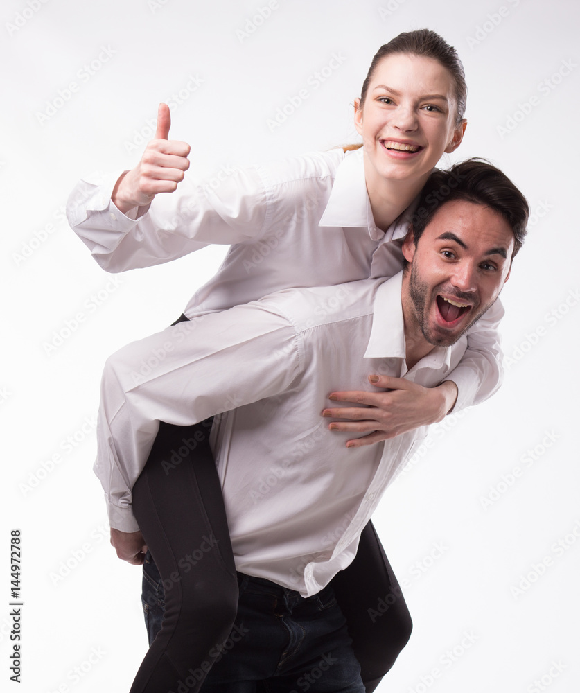 Young happy couple showing presentation pointing on placard over gray background Young happy couple showing presentation pointing on placard over gray background