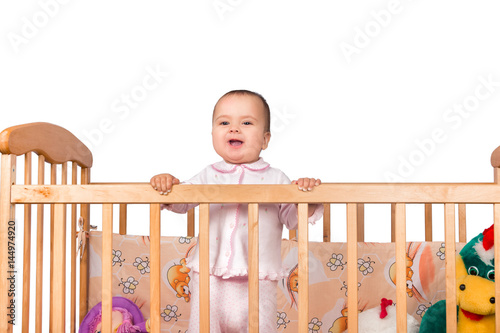 Infant child baby girl toddler in wooden bed on white background