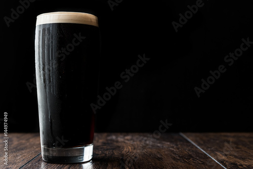 Canvas-taulu Dark beer on wooden surface. copy space.