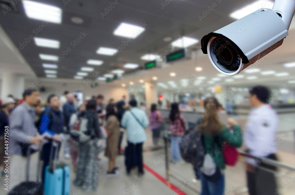 cctv security camera on blurred image of tourist queue at immigration control at airport, security technology concept. - obrazy, fototapety, plakaty 