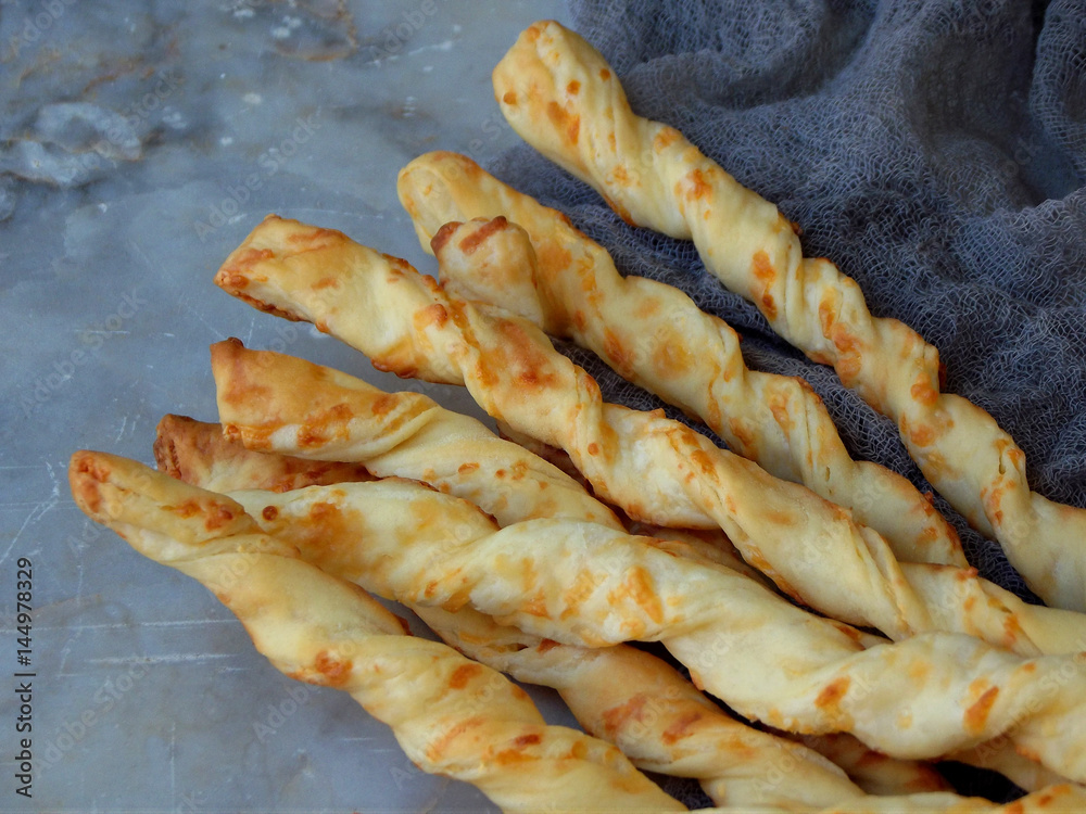 salty sticks of puff pastry sprinkled with cumin and Nigella on a wooden background salty sticks of puff pastry sprinkled with cumin and Nigella on a wooden background