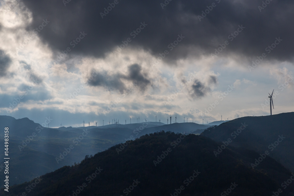 A cloudy panorama showing wind turbines on top of some hills A cloudy panorama showing wind turbines on top of some hills