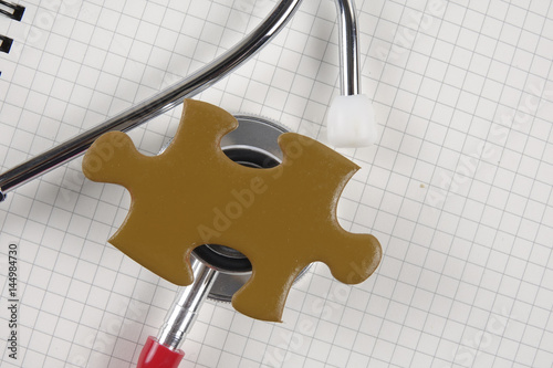 Medical concept with stethoscope,piece of puzzle and coins . photo