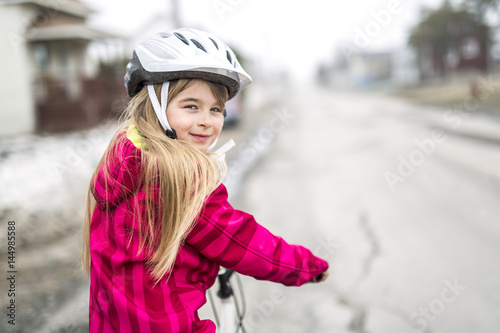 Little girl riding a bike in a city