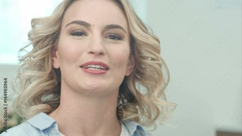 Happy attractive young woman talking to camera