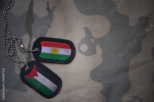Foto army blank, dog tag with flag of kurdistan and palestine on the khaki texture background