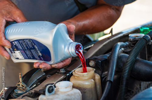 Machanic filling red hydrolic oil in service shop