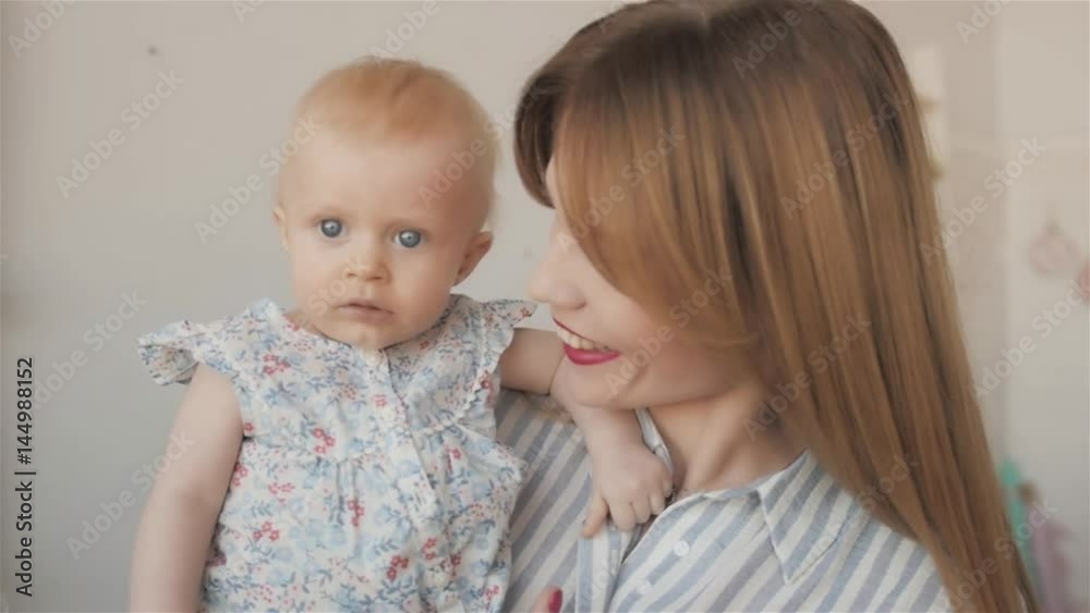 Portrait of happy mother and baby at home. Newborn Child on hands playing laughing and smiling, young beautiful mom and girl Portrait of happy mother and baby at home. Newborn Child on hands playing laughing and smiling, young beautiful mom and girl