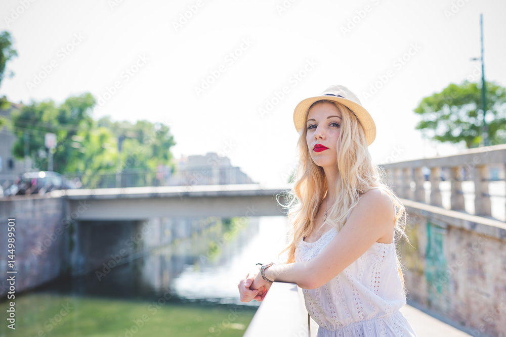 Young beautiful woman leaning looking away pensive outdoor in city back light - serious, getting away from it all, urban life concept