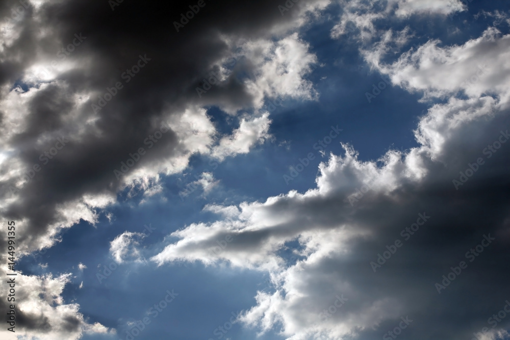 Blue sky opening between dark clouds background. Blue sky opening between dark clouds background.