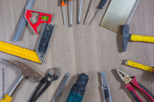 Different tools on a wooden background. Hammer, drill, pliers. Screwdriver, ruler, cutting pliers