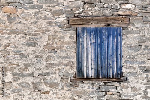 volets en vieux bois  bleus fermés  sur maison en pierre