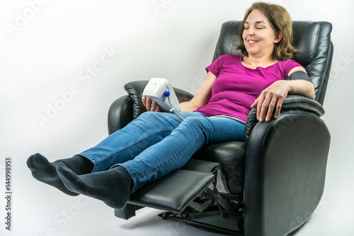 Εκτύπωση καμβά Pretty middle-age woman resting in black leather recliner armchair