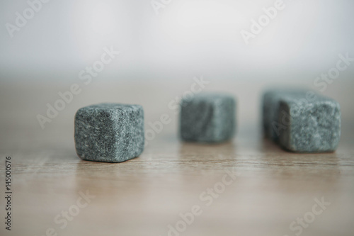 Stones for cooling whiskey on light wooden background