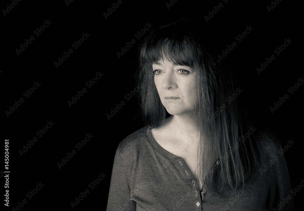 Portrait of mature woman looking pensive. Low key. Portrait of mature woman looking pensive. Low key.
