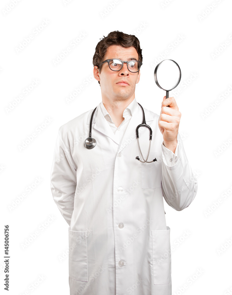 Surprised doctor using a magnifying glass against white background Surprised doctor using a magnifying glass against white background