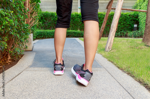 Sporty woman ankle sprain while jogging or running at park.