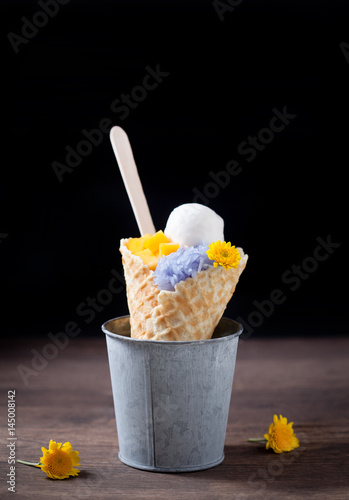 Obraz na płótnie Ice cream cones with sticky rice in a metal basket on wooden, selective focus w salonie