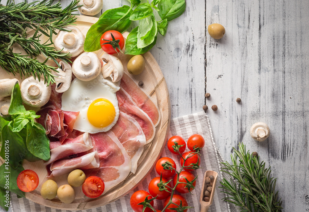 Healthy Mediterranean breakfast ingredients, ham, fried eggs, tomatoes Healthy Mediterranean breakfast ingredients, ham, fried eggs, tomatoes