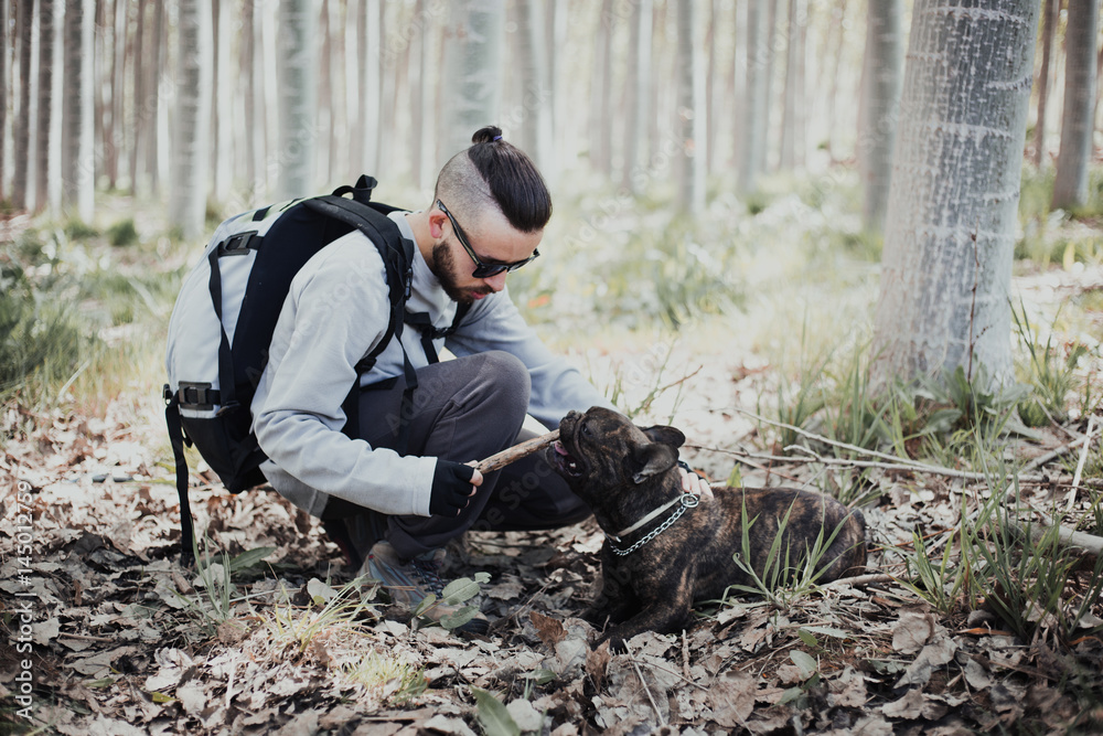 Young backpacker enjoying his dog in the forest Young backpacker enjoying his dog in the forest