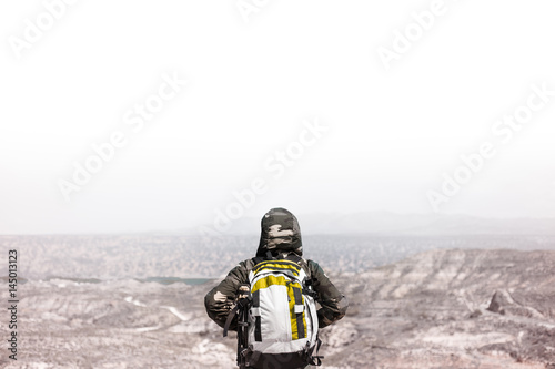 Backpacker man on top of a mountain looking at the skyline