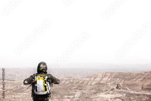 Backpacker man on top of a mountain looking at the skyline