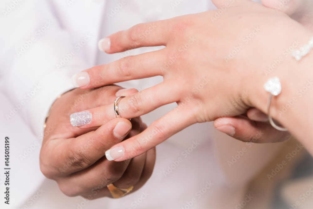 Close up hands of bride and groom putting on a wedding rings Close up hands of bride and groom putting on a wedding rings