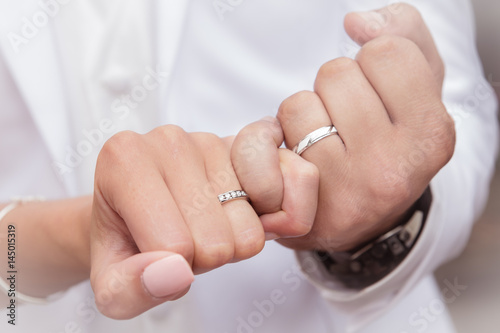 Close up hands of bride and groom putting on a wedding rings