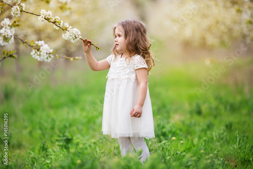 Pretty child girl in blossom garden