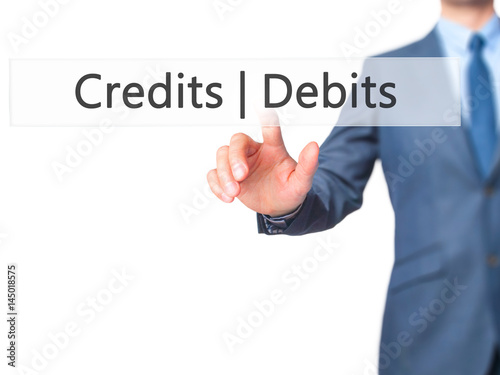 Credits Debits - Businessman hand pressing button on touch screen interface.
