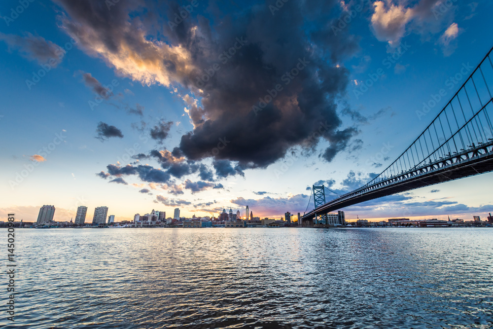 Obraz premium sunset skyline of philadelphia pennsylvania from camden new jersey with benjamin franklin bridge