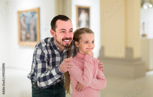 Father and small daughter exploring art paintings © JackF