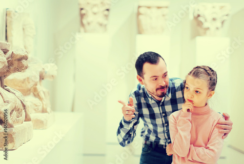 positive father and daughter regarding classical bas-reliefs in museum