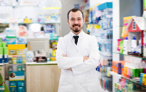 Glad male pharmacist suggesting useful drug © JackF