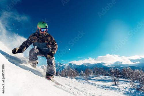 snowboarder is sliding with snowboard photo