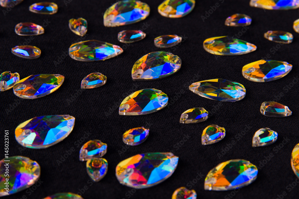 Precious stones crystals in the shape a tear drop on a black background.