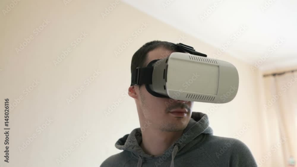 Man wearing virtual reality headset at living room. Man wearing virtual reality headset at living room.