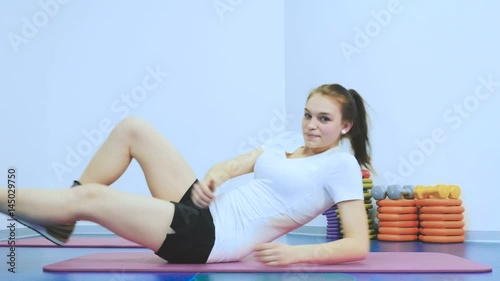 Cute girl training her leg with weight in rehabilitation center photo