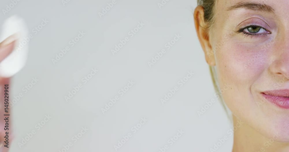 Portrait of a beautiful young girl smiling and looking at the camera, covers his eyes with cotton, on a white background. Concept: natural beauty, youth, skin care, always young, to love yourself. Portrait of a beautiful young girl smiling and looking at the camera, covers his eyes with cotton, on a white background. Concept: natural beauty, youth, skin care, always young, to love yourself.