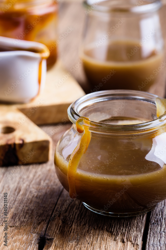 Homemade caramel sauce in glass jar Homemade caramel sauce in glass jar